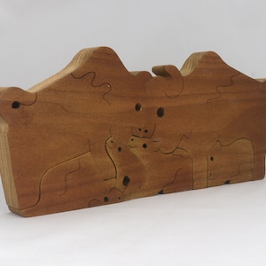 Wooden 6-piece bison family puzzle with two adult bison and four calves. The hardwood pieces interlock into one standing group or separate to stand alone. Handnmade in Tallahassee, Florida, USA by Odin's Toy Factory.