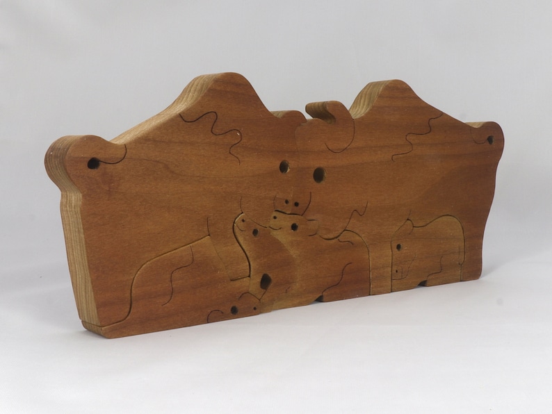 Wooden 6-piece bison family puzzle with two adult bison and four calves. The hardwood pieces interlock into one standing group or separate to stand alone. Handnmade in Tallahassee, Florida, USA by Odin's Toy Factory.