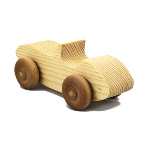 A small, handcrafted wooden toy convertible sports car, finished with a custom blend of oils and waxes, is the perfect gift for young children.