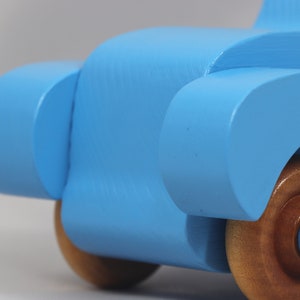 Handmade painted wooden toy car, baby blue convertible with fat fendered roadster design. Non-marring wheels finished with amber shellac.