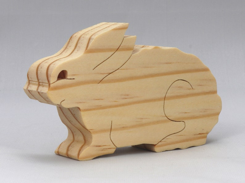 This is an unfinished wooden Rabbit cutout from solid wood using traditional woodworking techniques. Sanded smooth and ready to paint, stain, or customize. Freestanding design for small hands, toddlers, young children, crafters, collectors, and display. I take custom orders for any animal, quantity, and mix — including large ornament orders. Mix and match, request a different size, or send a drawing or pattern. Handmade by Odin's Toy Factory in Tallahassee, Florida, USA.