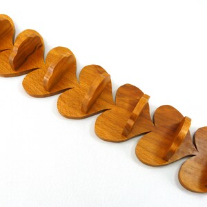 Handmade heart-shaped shelf crafted from reclaimed oak hardwood and finished with polyurethane. Perfect for displaying small items and adding rustic charm to home decor.