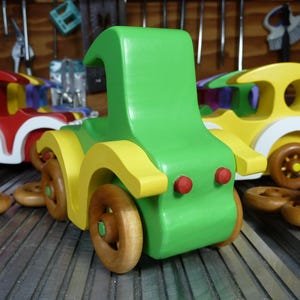 Handmade wooden toy car, vintage-style Model T sedan, painted bright green and yellow with spoked wheels, finished in amber shellac.  Handcrafted in Tallahassee, Florida, USA by Odin's Toy Factory.