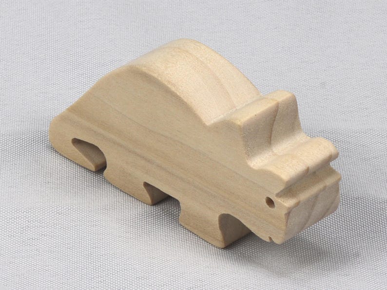 This is an unfinished wooden Wooden Toy Dinosaur Triceratops cutout from solid wood using traditional woodworking techniques. Sanded smooth and ready to paint, stain, or customize. Freestanding design for small hands, toddlers, young children, crafters, collectors, and display. I take custom orders for any animal, quantity, and mix — including large ornament orders. Mix and match, request a different size, or send a drawing or pattern. Handmade by Odin's Toy Factory in Tallahassee, Florida, USA.