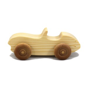 A small, handcrafted wooden toy convertible sports car, finished with a custom blend of oils and waxes, is the perfect gift for young children.