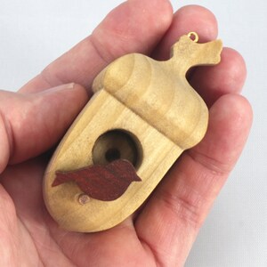 Handmade wooden miniature birdhouse ornament cut from wood with rounded edges, natural wood grain and color variations, finished with non-toxic shellac or food-safe oils and beeswax, lightweight and ready to hang. Made in Tallahassee, Florida, USA, by Odin's Toy Factory.