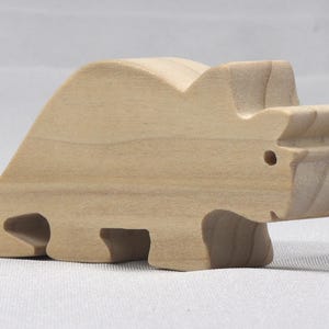 This is an unfinished wooden Wooden Toy Dinosaur Triceratops cutout from solid wood using traditional woodworking techniques. Sanded smooth and ready to paint, stain, or customize. Freestanding design for small hands, toddlers, young children, crafters, collectors, and display. I take custom orders for any animal, quantity, and mix — including large ornament orders. Mix and match, request a different size, or send a drawing or pattern. Handmade by Odin's Toy Factory in Tallahassee, Florida, USA.