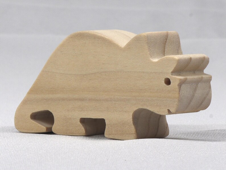 This is an unfinished wooden Wooden Toy Dinosaur Triceratops cutout from solid wood using traditional woodworking techniques. Sanded smooth and ready to paint, stain, or customize. Freestanding design for small hands, toddlers, young children, crafters, collectors, and display. I take custom orders for any animal, quantity, and mix — including large ornament orders. Mix and match, request a different size, or send a drawing or pattern. Handmade by Odin's Toy Factory in Tallahassee, Florida, USA.