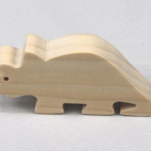 This is an unfinished wooden Wooden Toy Dinosaur Triceratops cutout from solid wood using traditional woodworking techniques. Sanded smooth and ready to paint, stain, or customize. Freestanding design for small hands, toddlers, young children, crafters, collectors, and display. I take custom orders for any animal, quantity, and mix — including large ornament orders. Mix and match, request a different size, or send a drawing or pattern. Handmade by Odin's Toy Factory in Tallahassee, Florida, USA.