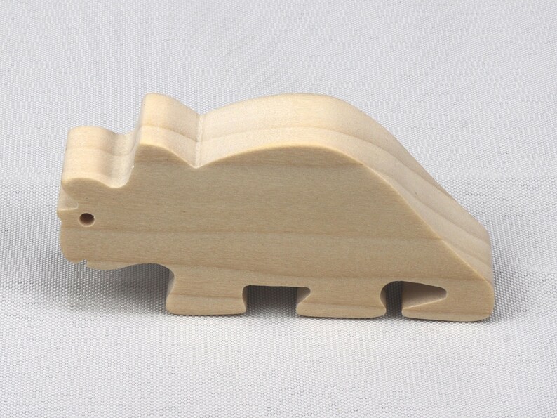 This is an unfinished wooden Wooden Toy Dinosaur Triceratops cutout from solid wood using traditional woodworking techniques. Sanded smooth and ready to paint, stain, or customize. Freestanding design for small hands, toddlers, young children, crafters, collectors, and display. I take custom orders for any animal, quantity, and mix — including large ornament orders. Mix and match, request a different size, or send a drawing or pattern. Handmade by Odin's Toy Factory in Tallahassee, Florida, USA.