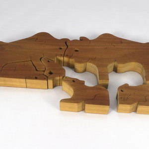 Wooden 6-piece bison family puzzle with two adult bison and four calves. The hardwood pieces interlock into one standing group or separate to stand alone. Handnmade in Tallahassee, Florida, USA by Odin's Toy Factory.