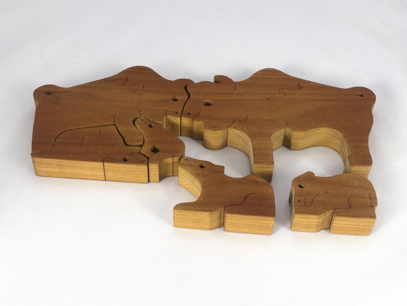 Wooden 6-piece bison family puzzle with two adult bison and four calves. The hardwood pieces interlock into one standing group or separate to stand alone. Handnmade in Tallahassee, Florida, USA by Odin's Toy Factory.