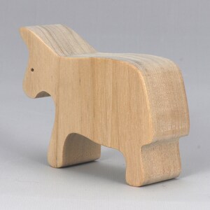 A handmade and unfinished wooden toy cow cutout is perfect for those who love to paint and customize their toys. It is freestanding and stackable, making it a versatile addition to any playroom or nursery. From My Itty Bitty Animal Collection.