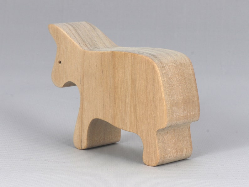 A handmade and unfinished wooden toy cow cutout is perfect for those who love to paint and customize their toys. It is freestanding and stackable, making it a versatile addition to any playroom or nursery. From My Itty Bitty Animal Collection.