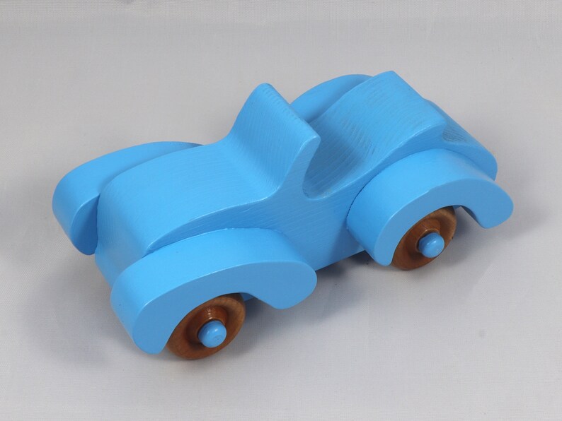 Handmade painted wooden toy car, baby blue convertible with fat fendered roadster design. Non-marring wheels finished with amber shellac.