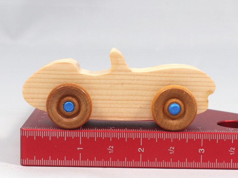 Handmade wooden toy car convertible sports coupe with a nontoxic satin polyethylene finish, amber shellac wheels, and metallic sapphire blue trim.