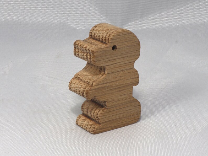 May include: A wooden toy shaped like a standing bear. The bear is made of light brown wood and has a simple, carved design.