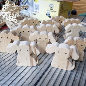 This is an unfinished wooden Puppy Dog cutout from solid wood using traditional woodworking techniques. Sanded smooth and ready to paint, stain, or customize. Freestanding design for small hands, toddlers, young children, crafters, collectors, and display. I take custom orders for any animal, quantity, and mix — including large ornament orders. Mix and match, request a different size, or send a drawing or pattern. Handmade by Odin's Toy Factory in Tallahassee, Florida, USA.