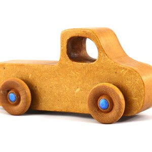 This handmade toy pickup truck from My Play Pal Collection is finished with amber shellac and metallic sapphire blue acrylic paint. It is just one of many unique wooden vehicles available.