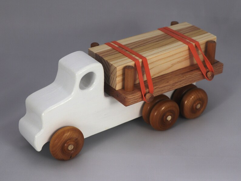 Handmade wooden toy lumber truck from Odin's Toy Factory Easy 5 Truck Fleet Collection. Painted lumber truck with acrylic body, shellac bed, and wheels. Measures approximately 9 inches long, 4 inches high, and 3.5 inches wide. Handmade in Tallahassee, Florida, USA. Custom colors available.