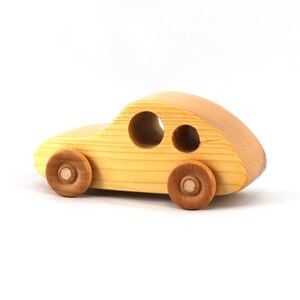 A handmade wooden toy car from the My Play Pal collection finished with durable satin polyurethane and amber shellac. It is made to order.