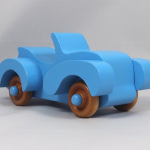 Handmade painted wooden toy car, baby blue convertible with fat fendered roadster design. Non-marring wheels finished with amber shellac.