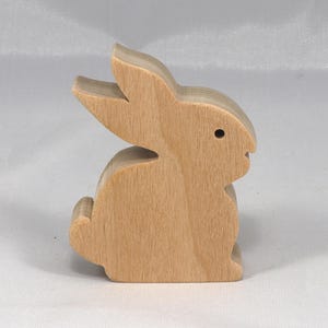 This is an unfinished wooden Rabbit cutout from solid wood using traditional woodworking techniques. Sanded smooth and ready to paint, stain, or customize. Freestanding design for small hands, toddlers, young children, crafters, collectors, and display. I take custom orders for any animal, quantity, and mix — including large ornament orders. Mix and match, request a different size, or send a drawing or pattern. Handmade by Odin's Toy Factory in Tallahassee, Florida, USA.