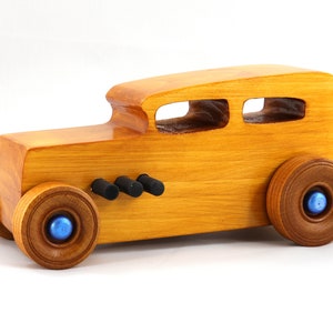 Handcrafted wooden hot rod toy car modeled after a classic '32 sedan. Finished with amber shellac and adorned with metallic sapphire blue and black trim. This unique piece is part of my Hot Rod Collection.