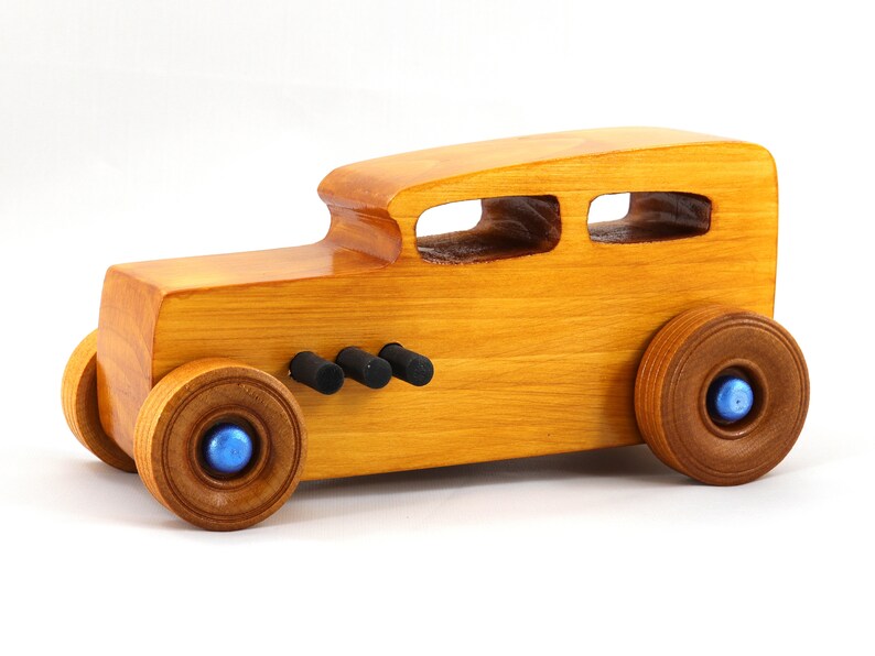 Handcrafted wooden hot rod toy car modeled after a classic '32 sedan. Finished with amber shellac and adorned with metallic sapphire blue and black trim. This unique piece is part of my Hot Rod Collection.