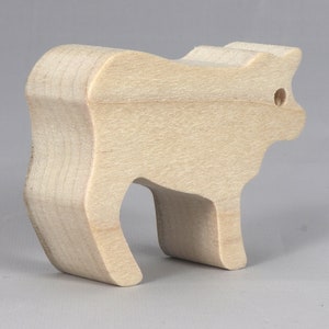 Handmade unfinished wooden toy baby calf cutout, unpainted and ready to paint, freestanding farm animal figure from Odin's Toy Factory’s  Itty Bitty Animal Collection. Handcrafted in Tallahassee, Florida, USA, using reclaimed natural wood offcuts. Perfect for imaginative play, stacking, collectors, and crafting.