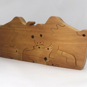 Wooden 6-piece bison family puzzle with two adult bison and four calves. The hardwood pieces interlock into one standing group or separate to stand alone. Handnmade in Tallahassee, Florida, USA by Odin's Toy Factory.