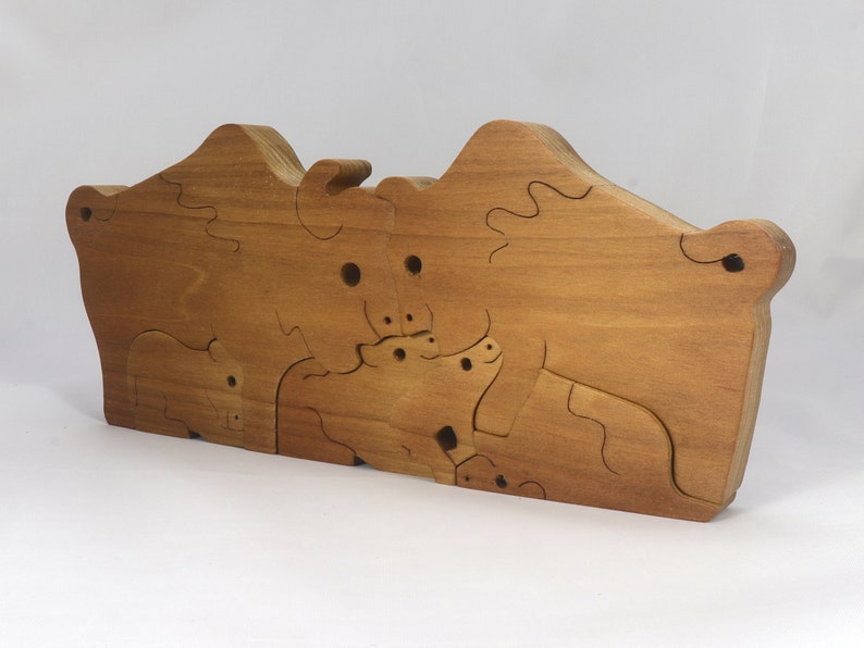 Wooden 6-piece bison family puzzle with two adult bison and four calves. The hardwood pieces interlock into one standing group or separate to stand alone. Handnmade in Tallahassee, Florida, USA by Odin's Toy Factory.