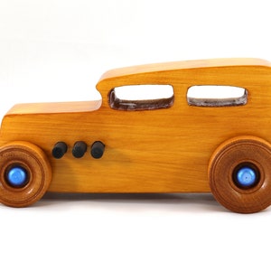 Handcrafted wooden hot rod toy car modeled after a classic '32 sedan. Finished with amber shellac and adorned with metallic sapphire blue and black trim. This unique piece is part of my Hot Rod Collection.