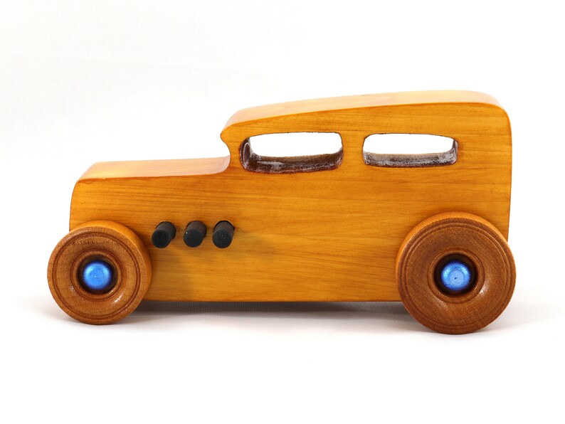 Handcrafted wooden hot rod toy car modeled after a classic '32 sedan. Finished with amber shellac and adorned with metallic sapphire blue and black trim. This unique piece is part of my Hot Rod Collection.