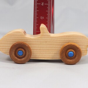 Handmade wooden toy car convertible sports coupe with a nontoxic satin polyethylene finish, amber shellac wheels, and metallic sapphire blue trim.