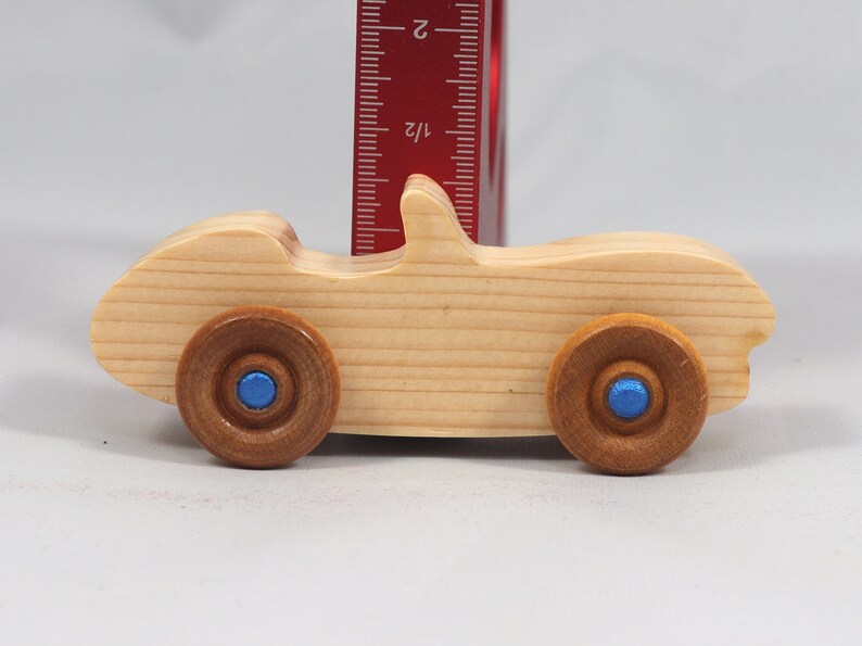 Handmade wooden toy car convertible sports coupe with a nontoxic satin polyethylene finish, amber shellac wheels, and metallic sapphire blue trim.