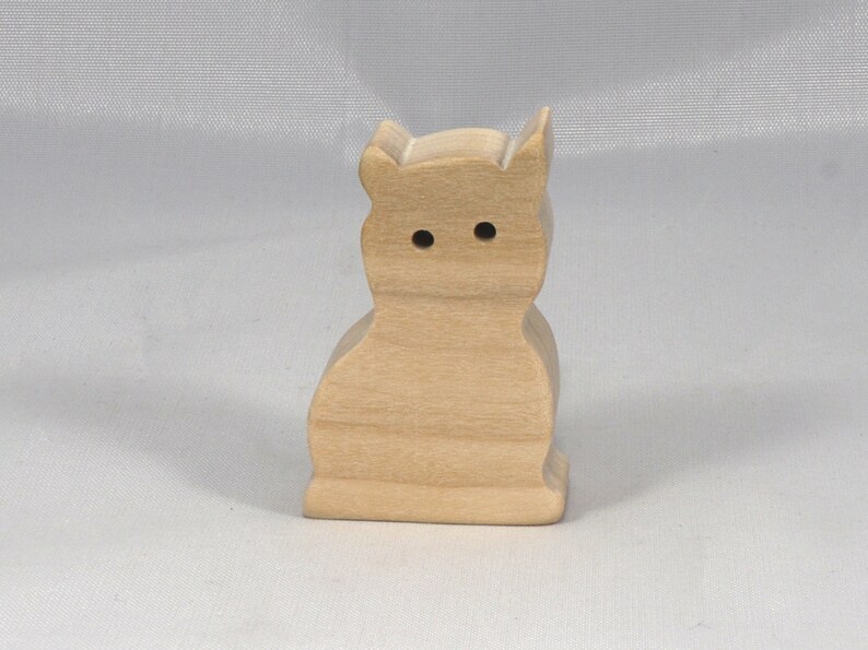 A handmade freestanding wooden toy cat cutout 1/2-3/4 inches thick is made from various kinds of wood sanded smooth and ready to paint. It is excellent for kids' crafts, pretend, or stacking toys. Other sizes are available with a custom order.