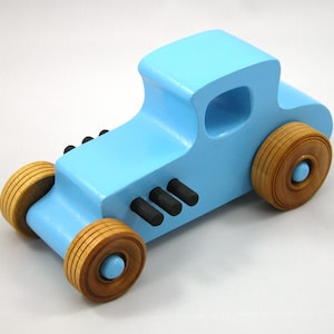Handmade wooden toy car modeled after a '27 T-Coupe, finished with baby blue and black acrylic paint with nonmarring amber shellac wheels from my hot rod collection.