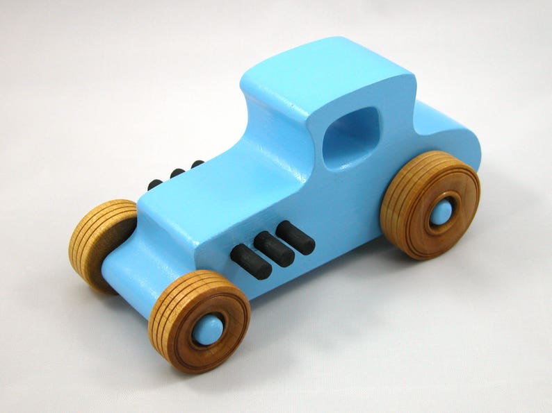 Handmade wooden toy car modeled after a '27 T-Coupe, finished with baby blue and black acrylic paint with nonmarring amber shellac wheels from my hot rod collection.