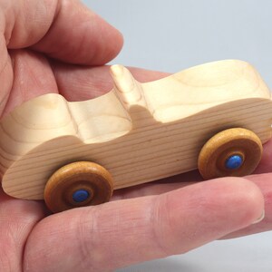 Handmade wooden toy car convertible sports coupe with a nontoxic satin polyethylene finish, amber shellac wheels, and metallic sapphire blue trim.