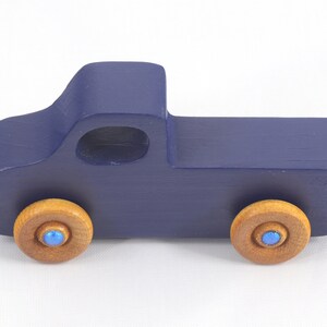 Handmade wooden toy pickup truck handmade and painted navy blue with amber shellac wheels and metallic sapphire blue trim. It's a little blue truck from my Play Pal Collection.