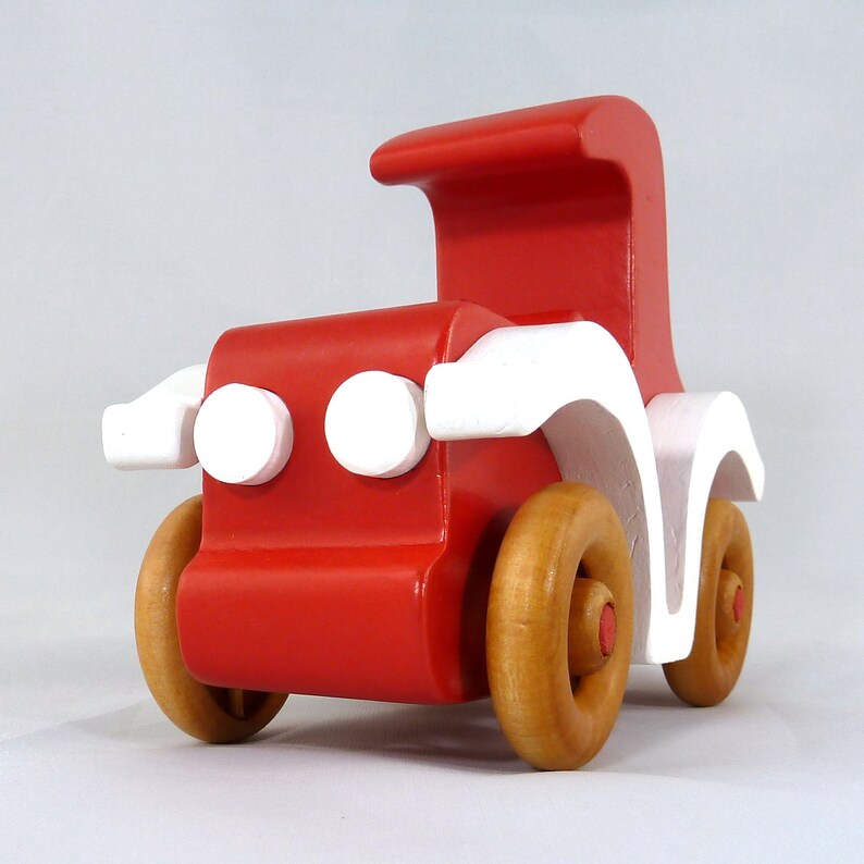 Handmade wooden toy car, vintage style red Model T Coupe by Odin's Toy Factory. Two-tone red and white acrylic paint with spoked wooden wheels finished in amber shellac. Approximate dimensions: 5 inches long, 4 inches high, 2.5 inches wide. Part of Bad Bob’s Custom Motors Collection. Crafted from natural wood using traditional woodworking tools. Handmade in Tallahassee, Florida, USA.