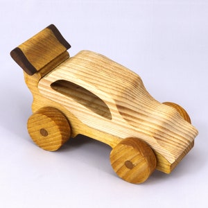 Handmade wooden toy car finished with nontoxic clear amber shellac and contrasting wood trim. Part of the Speedy Wheels Collection. Handcrafted in Tallahassee, Florida, USA. Length 5-1/2 inches, width 2-1/2 inches, height 2-1/2 inches. Made at Odin's Toy Factory.
