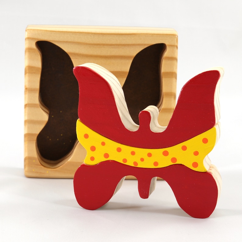 A wooden three-piece butterfly tray puzzle, handmade and finished. The butterfly is painted bright red and yellow with orange spots. The wooden tray is finished with clear shellac. It is one of four puzzles in my Puzzle Pals Collection.