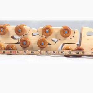 Handmade wooden toy truck play set includes three cars and a tractor-trailer finished with clear and amber shellac with metallic sapphire blue trim.