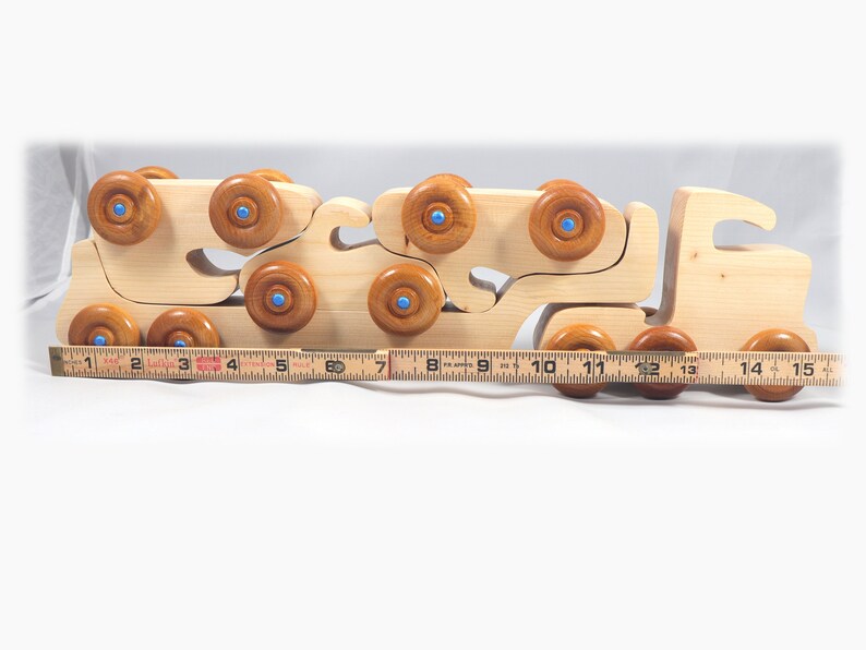 Handmade wooden toy truck play set includes three cars and a tractor-trailer finished with clear and amber shellac with metallic sapphire blue trim.