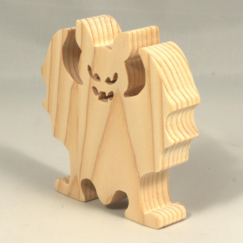 Handmade unpainted wooden Halloween bat cutout, freestanding light-colored solid wood figure with spooky carved face and outstretched wings, ready to paint, from my Snazzy Spooks collection.