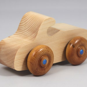 Handmade wooden toy car. The body is finished with clear shellac, and the wheels are finished with amber shellac. The hubs are painted with metallic sapphire blue trim.