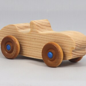 Handmade wooden toy car convertible sports coupe with a nontoxic satin polyethylene finish, amber shellac wheels, and metallic sapphire blue trim.