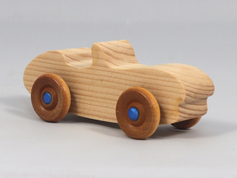 Handmade wooden toy car convertible sports coupe with a nontoxic satin polyethylene finish, amber shellac wheels, and metallic sapphire blue trim.